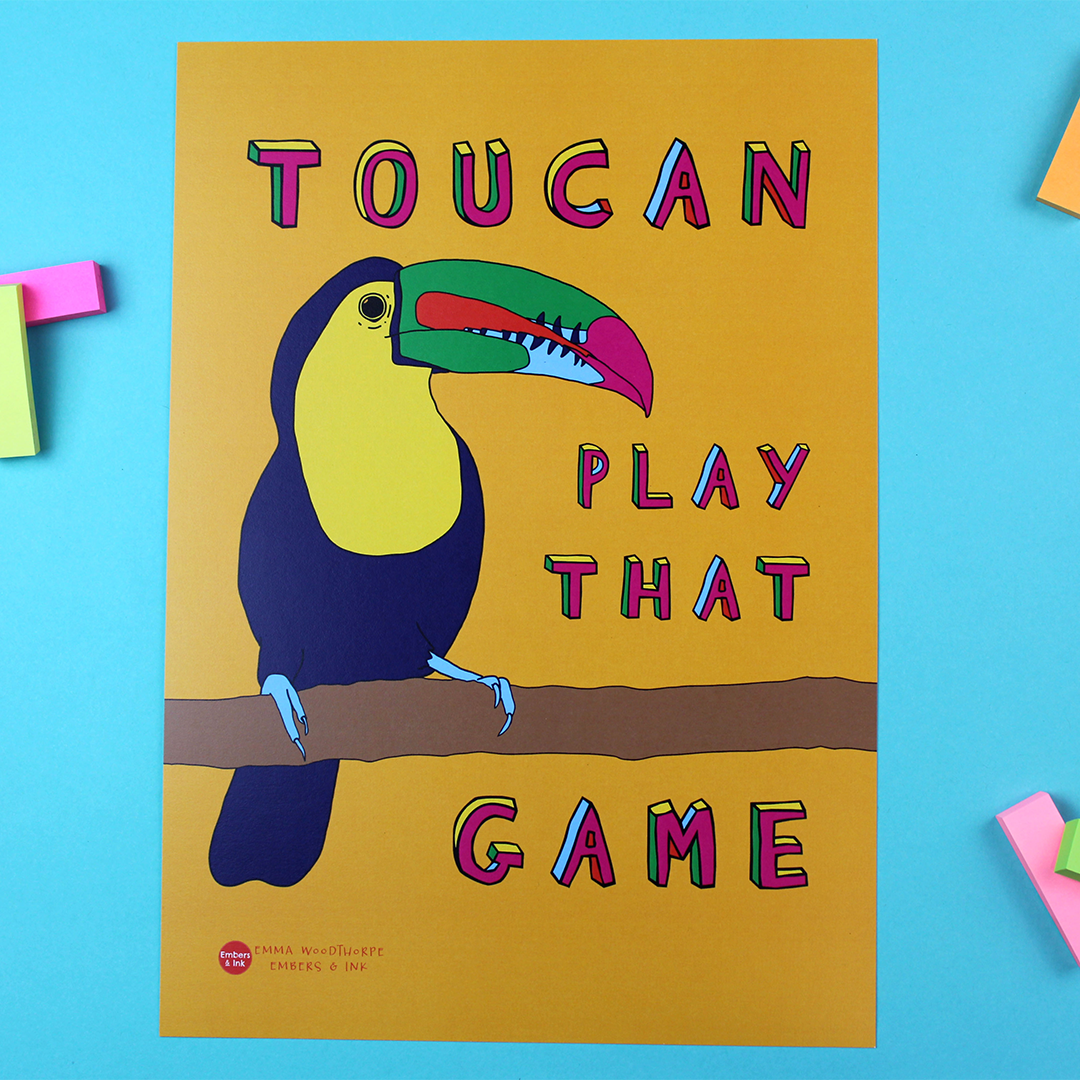 the Toucan Play That Game poster is on a table