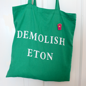 The pink paw pin is shown on a green cotton tote bag.