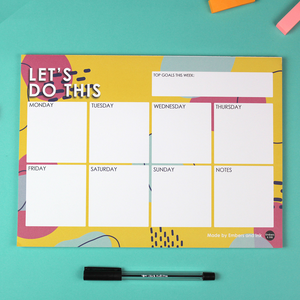 Image shows an A4 Landscape orientated planner with 50 tearable sheets. Each sheet has 8 square boxes for the days of the week plus a notes box. At the top there is a box entitles 'top goals this week' and the whole page has a title 'Let's Do This' on a pink yellow and blue patterned background.