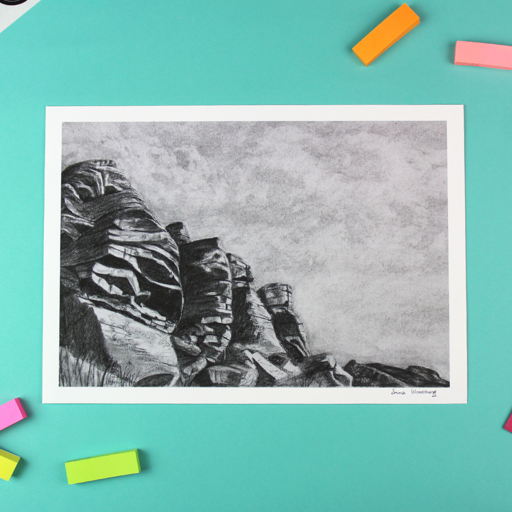 The image shows a landscape orientated print of a charcoal drawing. The drawing is of a rock formation known as Flying Buttress in the Peak District.