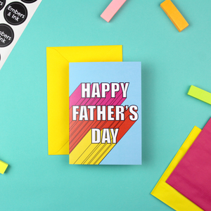A blue cards and a yellow envelope. The card has white writing that reads 'Happy Father's Day'. It has a 3D effect, with pink, orange and yellow colours.