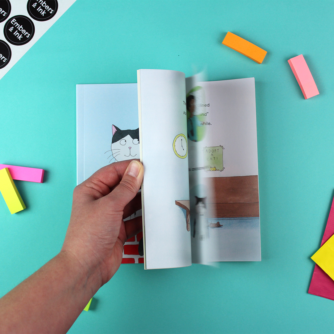 A hand flicks through the pages of Our Dave to show the illustrated pages inside.