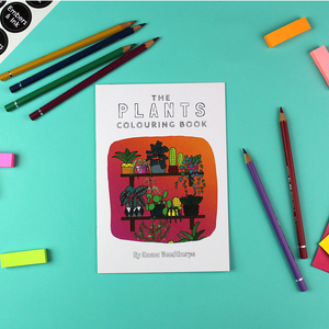 The plants colouring book lays on a table surrounded by coloured pencils