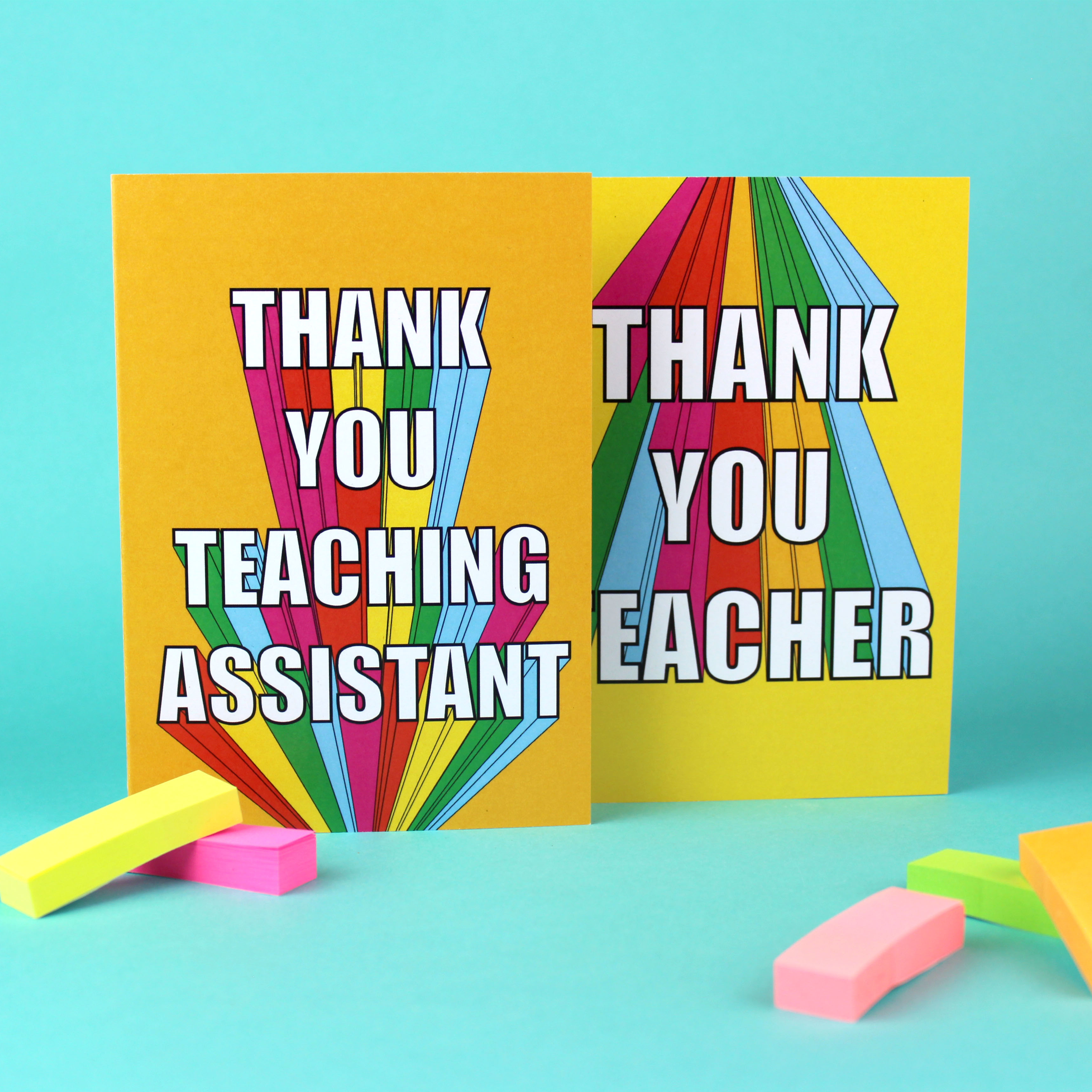 Two cards are shown, one with a yellow background and one with an orange background. Both cards have rainbow block lettering. One card reads Thank you teaching assistant. The other reads Thank you teacher.