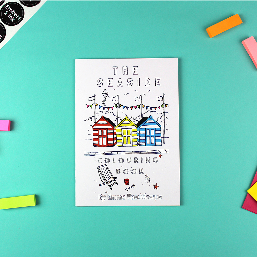 The seasaide colouring book is shown laying on a table.