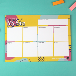 Showing the Let's Do This Notepad Planner with boxes to plan each day of the week plus a notes nox.It also includes a Top Goals This week bx and the top and a title on the whole page of Let's Do This. The background image is colourful with yellow pink and blue shapes.