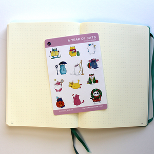 the cat sticker sheet is shown on an open journal, hinting that they can also be used when bullet journalling to make your pages look cute.