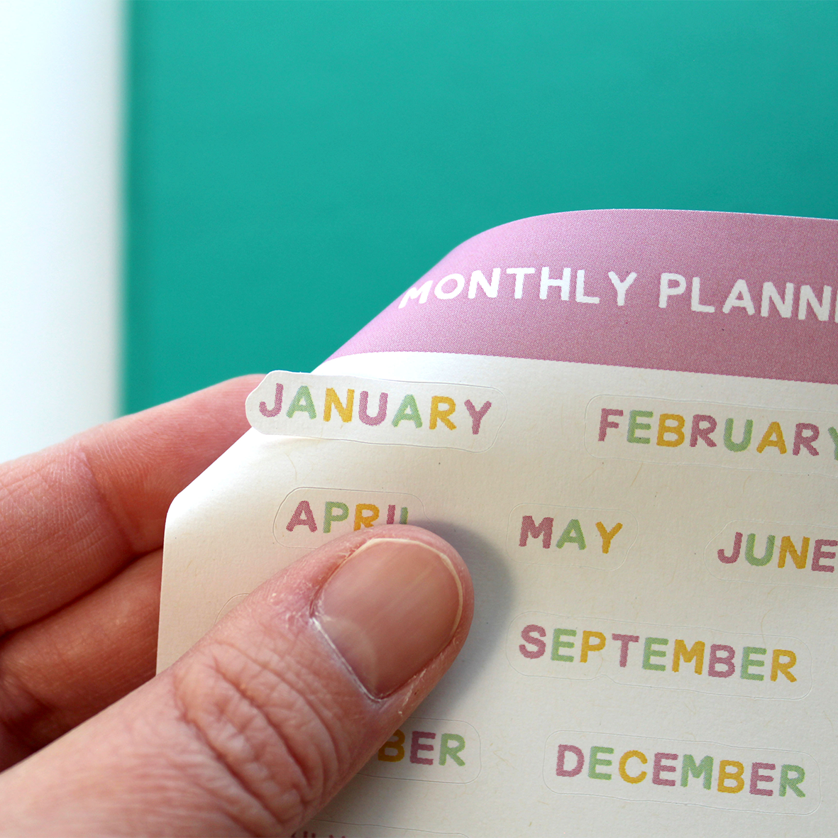 A hand is shown easily peeling the January sticker