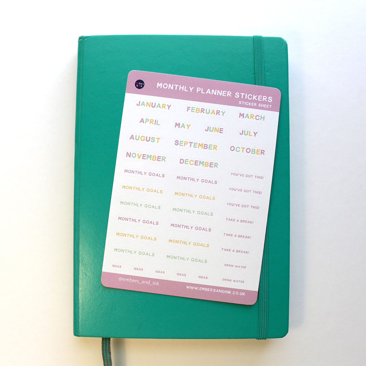 The monthly planner stickers are shown laying on top of a closed journal