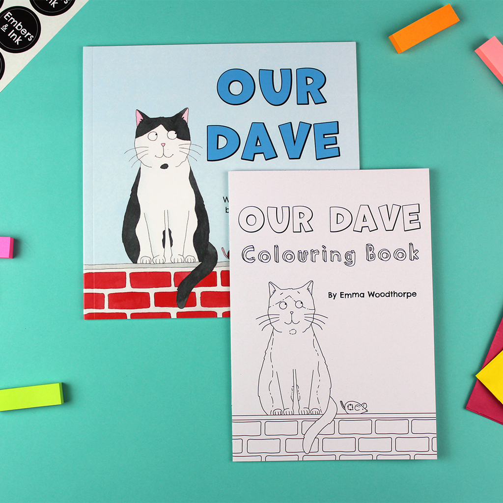on a table lays the Our Dave rhyming children's picture book and the Our Dave colouring Book. Both covers show a cat sitting on a wall next to a toy mouse. The children's book is coloured blue, red, black and white and the colouring book is black and white