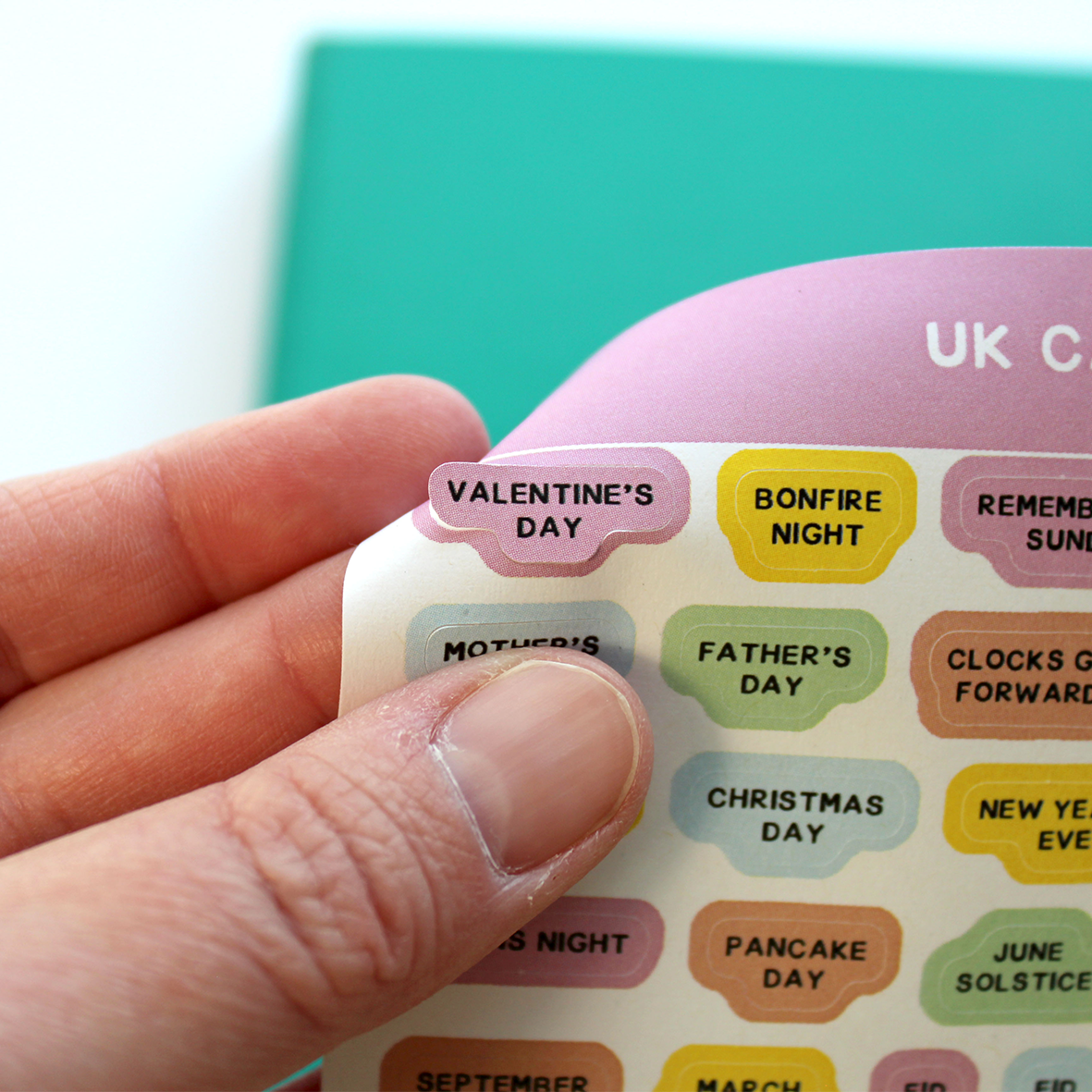 A close up is shown of a hand easily peeling the Valentine's Day sticker off