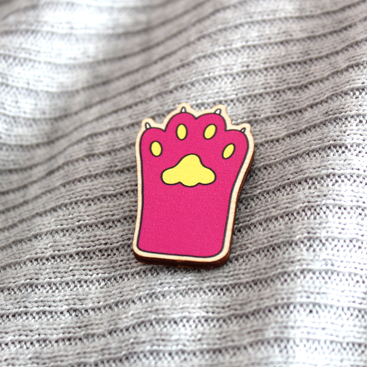 The pink paw in badge is shown on a grey jumper