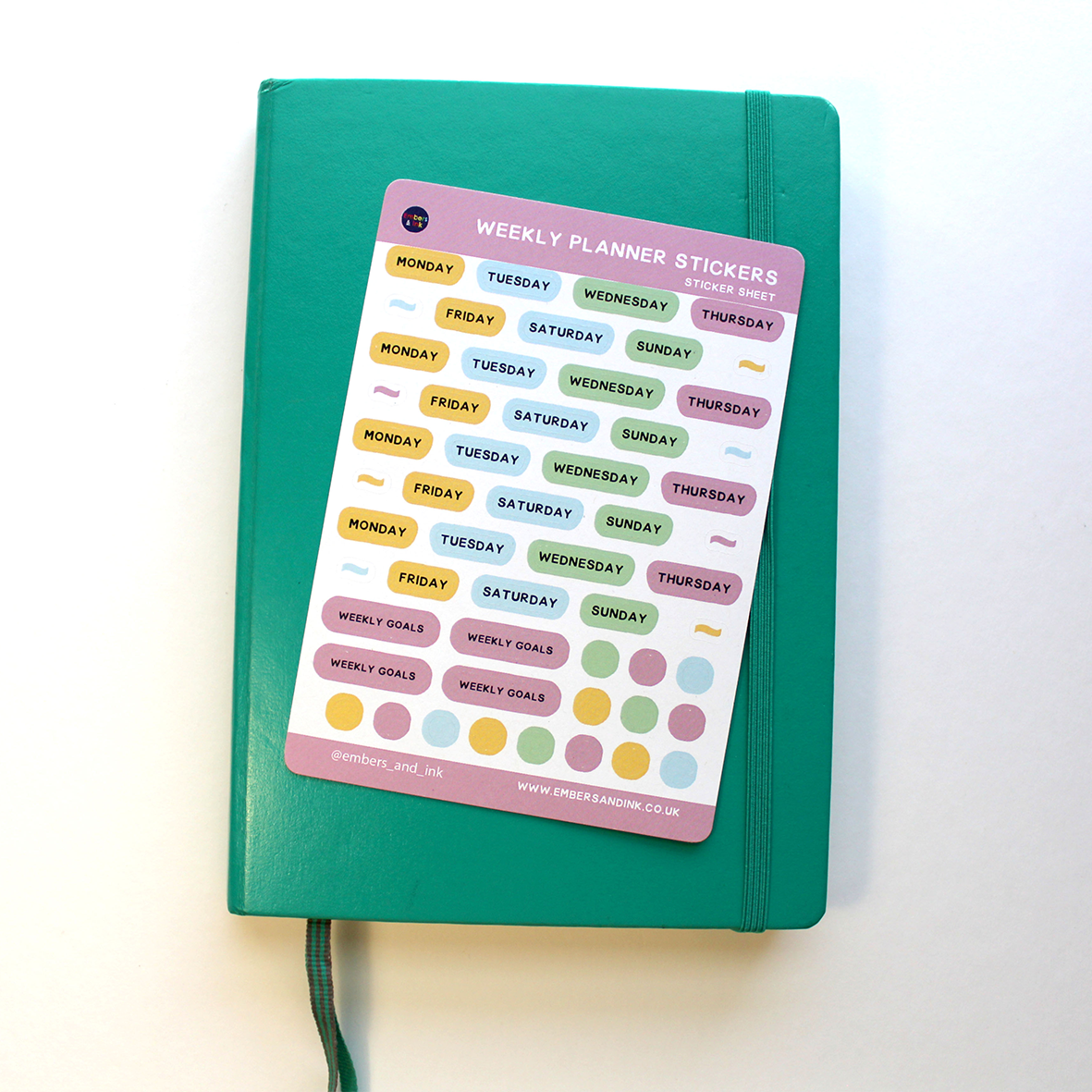 the weekly planner sticker sheet is shown resting on a closed journal.