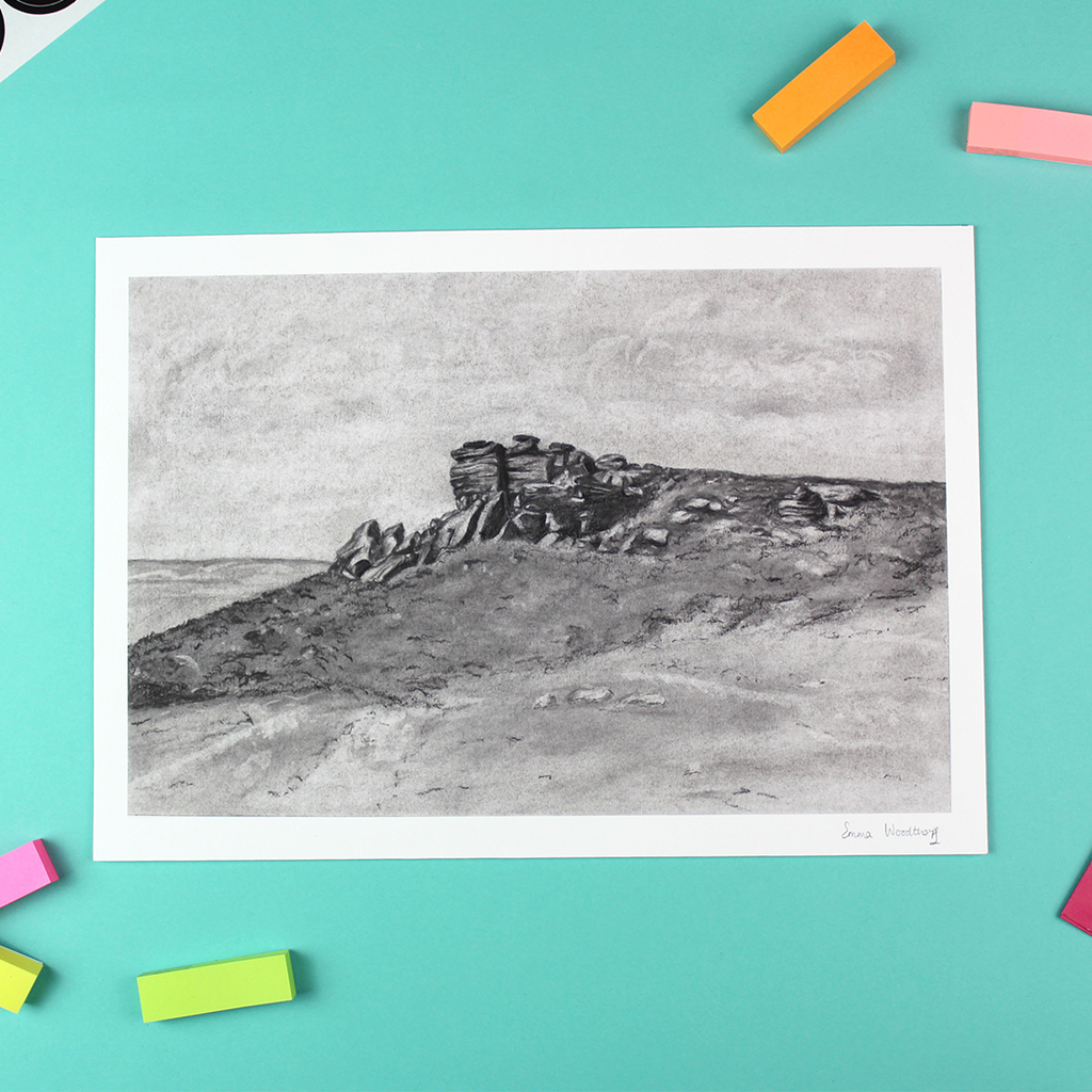 Image shows a landscape orientated black and white print of a charcoal landscape. The landscape includes a rock formation, known as White Tor in the Peak District.